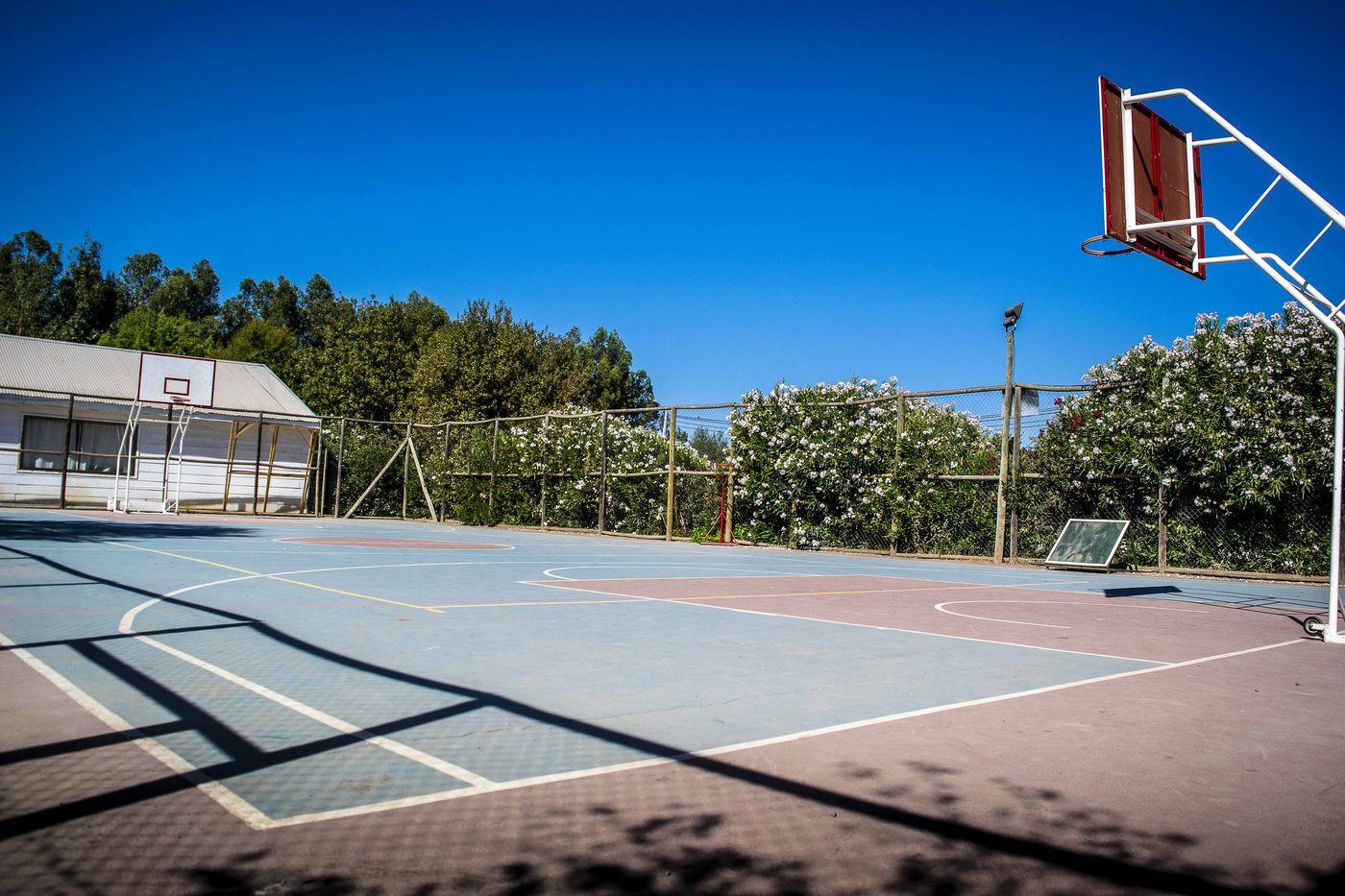 Multicancha de básquetbol frente a la capilla
